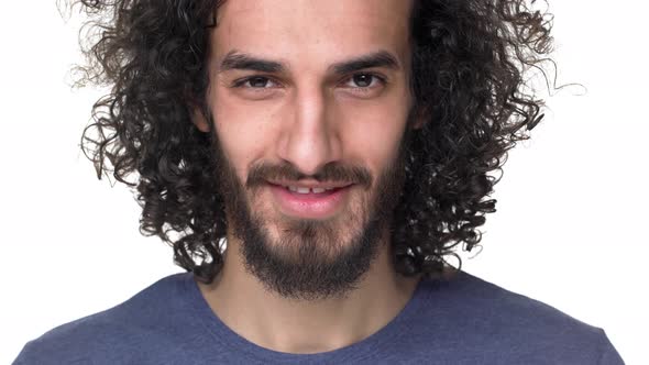 Closeup Portrait of Hairy Guy 27y with Curly Hair in Casual Dark Blue Tshirt Smiling While Being in alt