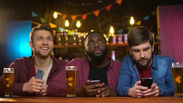 Multiethnic Male Friends Watching Football Match in Pub, Upset With Team Losing alt