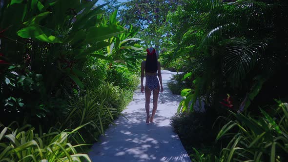 Back View Girl In Swimming Suit Walking Alone In Resort on Sunny Day Slow Motion