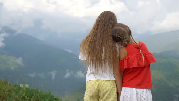 Beautiful Happy Little Girls in Mountains in the Background of Fog