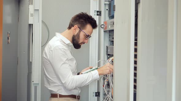 Network Engineer Working In Server Room.It Specialist On Computer Console In Server Room Data Center alt