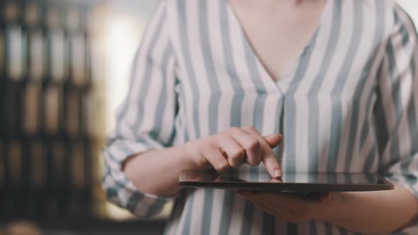 Woman Working on a Futuristic Tablet with a Hologram Earth and Text 5G.  alt