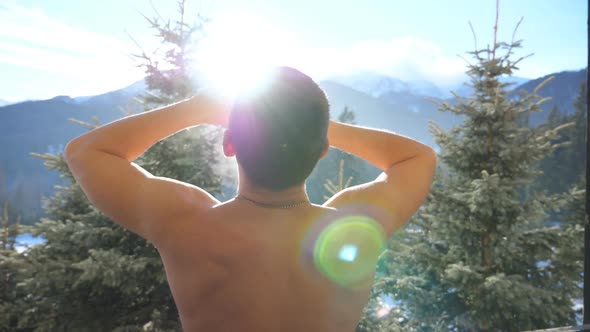 Close Up of Handsome Athletic Man Standing on Balcony and Stretching on Sunny Day. Young Guy alt