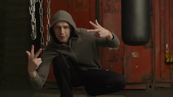 Gangster Rapper in Hoodie Making Cool Hand Gesture alt