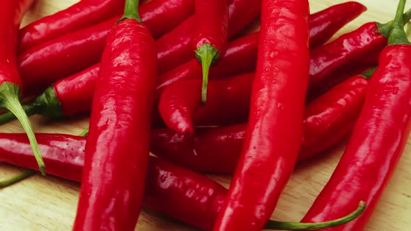 On Wood Plank Ripe Red Long Hot Chili Peppers are the World's Number One Culinary Delight and Cash alt