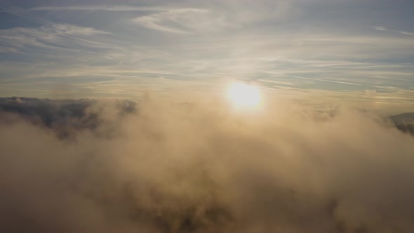 Surreal View Flying through Clouds at Sunset  