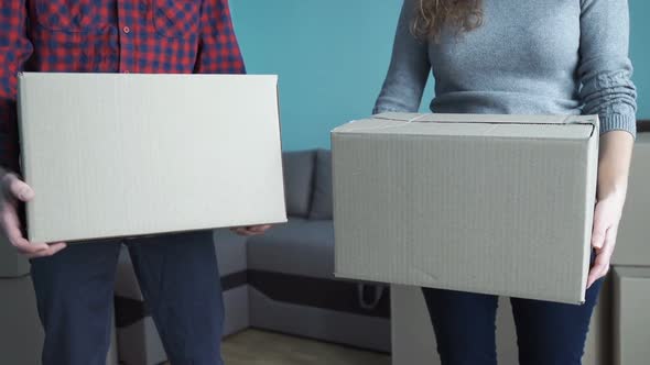 Young Couple Collects Things in a Box for Moving to a New Apartment