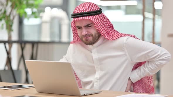 Tired Arab Businessman with Laptop Having Back Pain in Office  alt
