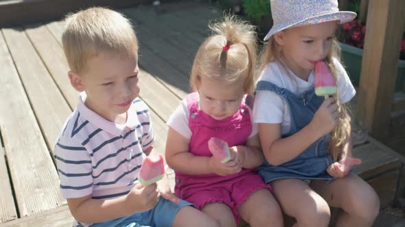 Three Cute Little Children Enjoys Delicious Ice Cream Cone alt