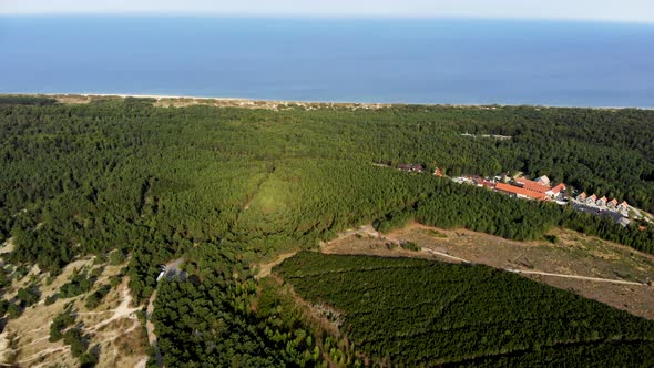AERIAL: Panoramic shot of Green Pine Forest near the Baltic Sea shore in Nida alt