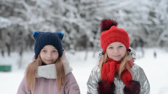 Two Little Sisters Portrait in Winter Snowy Park alt