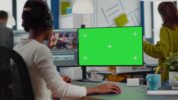Black Videographer Using Computer with Chroma Key alt