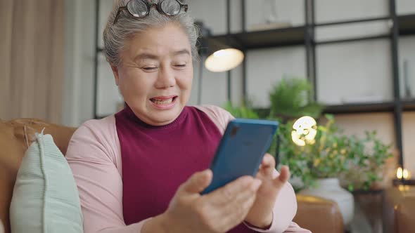 asian grandmother sit casual relax hand use smartphone technology device video call
