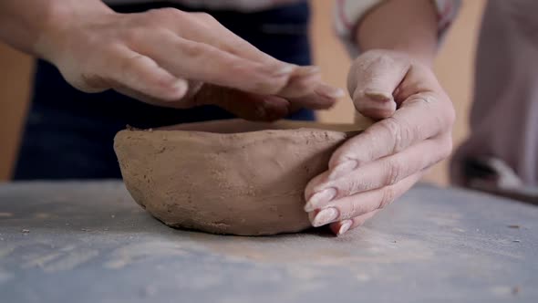 Woman Holding Clay in Hands and Making Earthenware in Studio