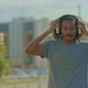 Darkskinned Man Walks Around the City in Headphones and Smiles - VideoHive Item for Sale
