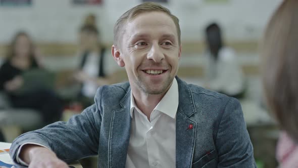 Designer Speaking with Colleague and Smiling alt