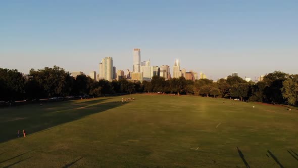 Aerial Drone shot from Zilker Park, going towards downtown Austin, Texas. People in zilker park play alt