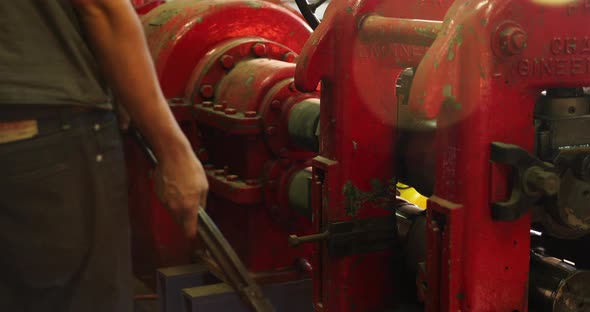 Bladesmith working with hot metal at press alt