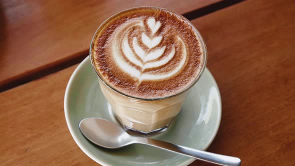 Cup of Cappuccino Coffee on Wooden Table alt