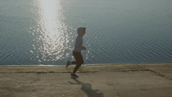 Man Runner Is Training Near Lake