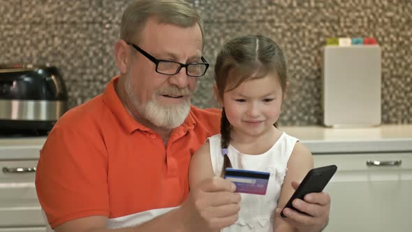 Grandfather and Granddaughter Choose a Gift for the Girl in the Online Store alt
