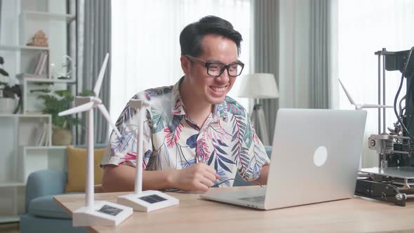 Success Man With Laptop Computer Programming Electric Wind Turbine Model At Home alt