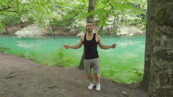 Sporty man skipping rope in nature. alt