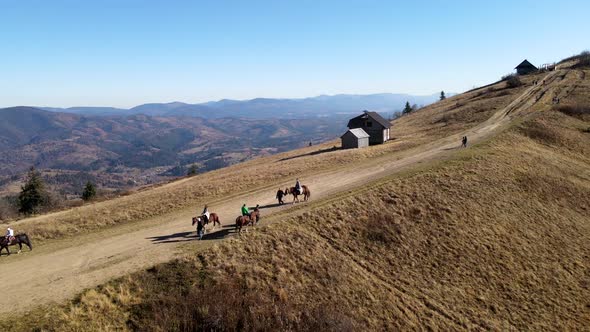 Aerial View People Riding Horse Attraction at the Top of Mountain alt
