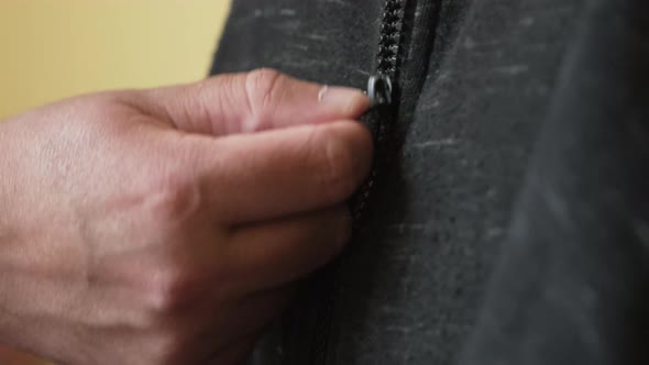 Man Zipping Up Zip on Hoodie, Close Up alt