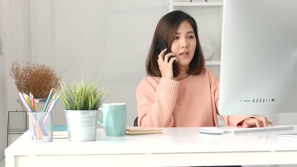 Young Asian business owners using computer pc and smartphone at the home office.