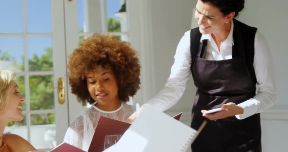 Friends placing order to waitress alt