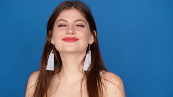 Portrait of a Girl in the Studio on a Blue Background. alt