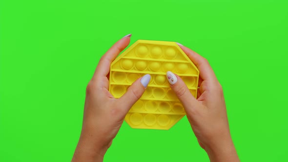 Girl Hands Squeezing Presses Colorful Antistress Touch Screen Push Pop It Toy Game on Chroma Key alt