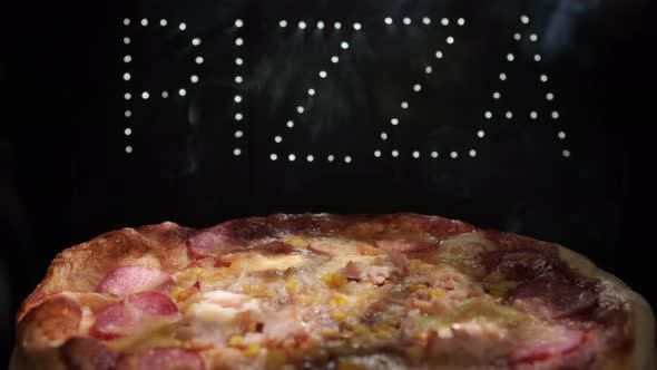 Delicious Fresh Italian  Pizza On A Black Background With The Effect Of Light Inscription Pizza