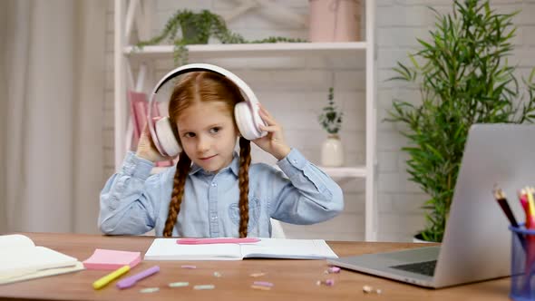 Happy Little Child Girl Is Listening To Music on Headphones.