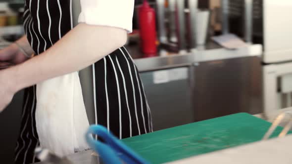 Chefs in Protective Masks and Gloves Prepare Food in the Kitchen of a Restaurant or Hotel High alt