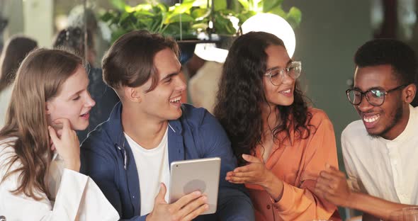 Crop View of Millennial Colleagues Communicating and Smiling. Cheerful Young People Using Tablet alt