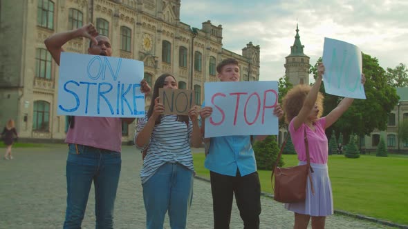 Young People Protesting Holding Placards with Inscriptions Outdoors alt