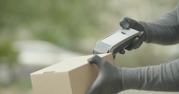 Courier in Rubber Gloves Delivering Parcel and using  Terminal  alt