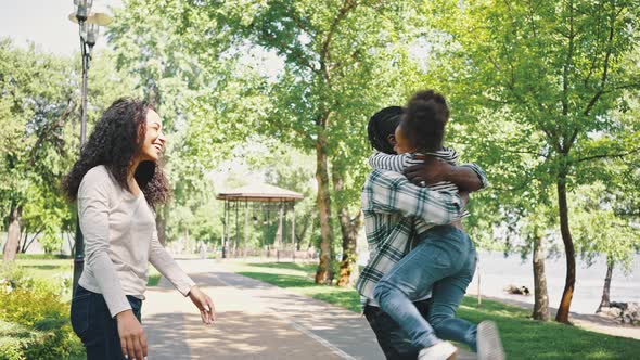 Mother and Father Walk with Their Little Daughter in the Park alt