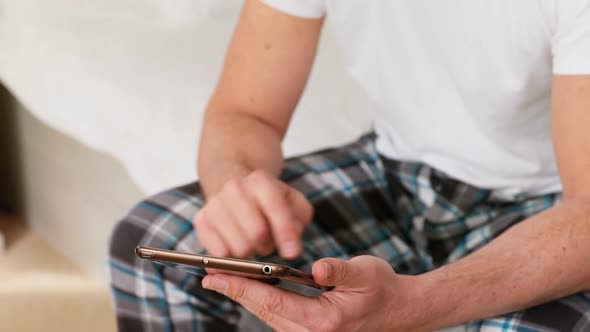 Man using digital tablet in bedroom at home 4k alt