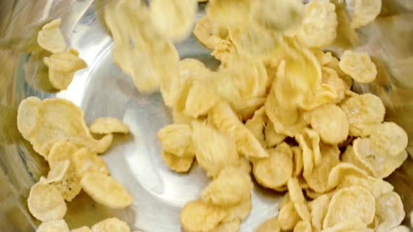 Corn Flakes Pouring Into Stainless Steel Bowl Slow Mo. Cereal Breakfast Concept