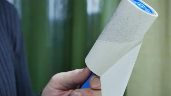 Man's Hand Removes the Used Layer From the Roller for Cleaning Clothes