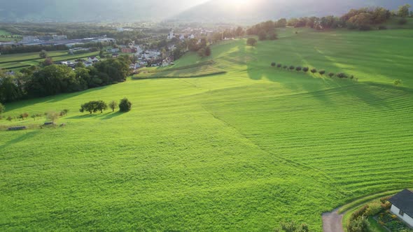 Aerial Landscape View of Ideal Green Fields in Liechtenstein Alps at Sunset alt