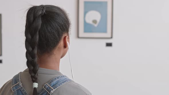 Girl Using Audio Guide in Gallery alt