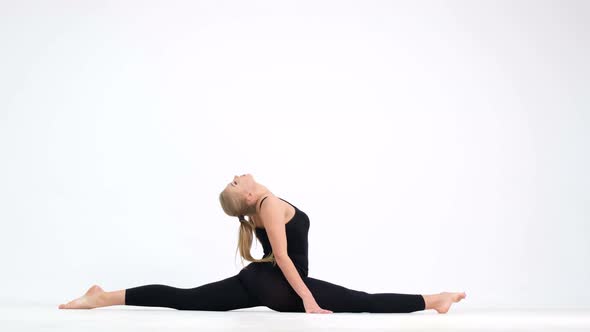 A woman doing yoga exercises on a white background at home. alt