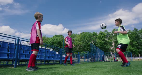 Young Boys Play Soccer and Pass the Ball To Each Other, Training Day on the Football Field alt