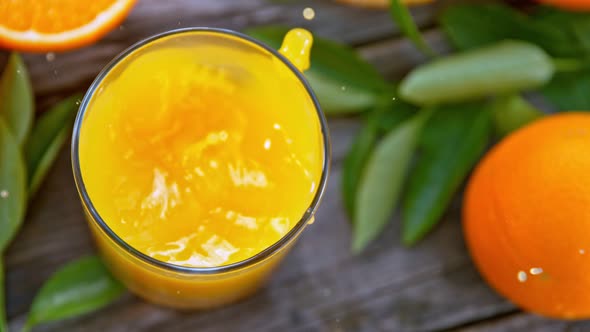 Super Slow Motion Shot of Ice Falling to Fresh Orange Juice in a Glass at 1000Fps alt