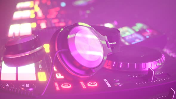 DJ set with headphones in dense fog club atmosphere with colorful lights. 4KHD alt