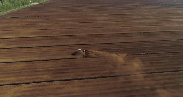 Peat Harvesting Tractor Extracting Turf in Drained Bog Aerial View alt